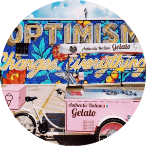 A pink ice cream cart in front of a wall